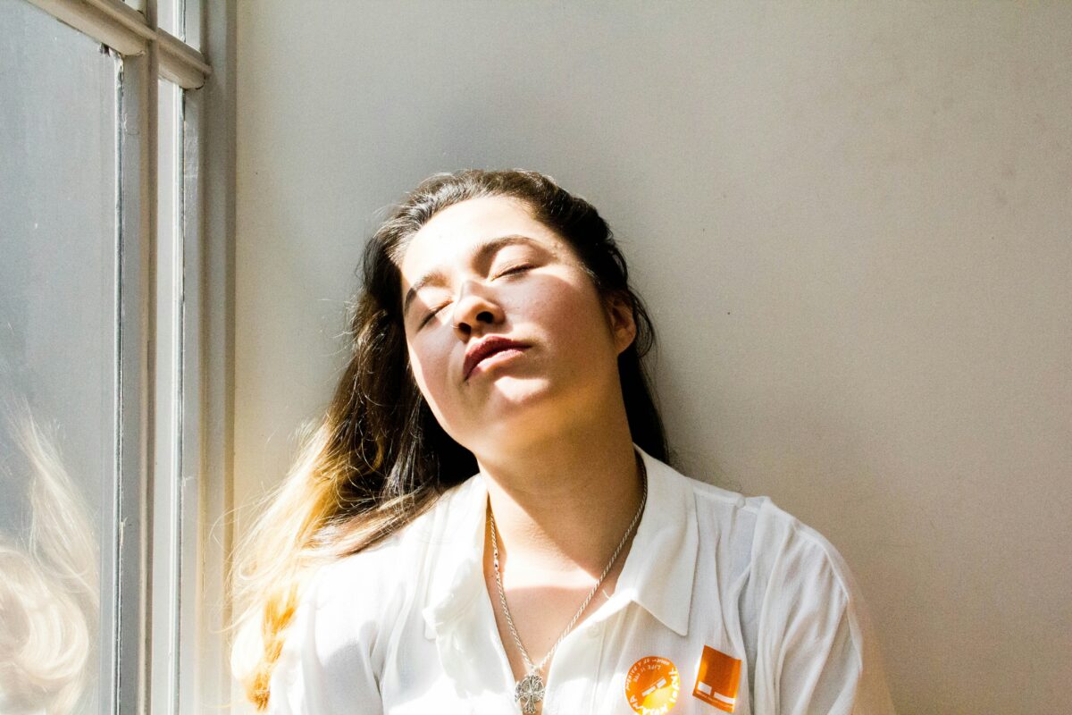 朝活がつらい主婦が眠そうに朝日を浴びている様子（朝起きられない悩み）